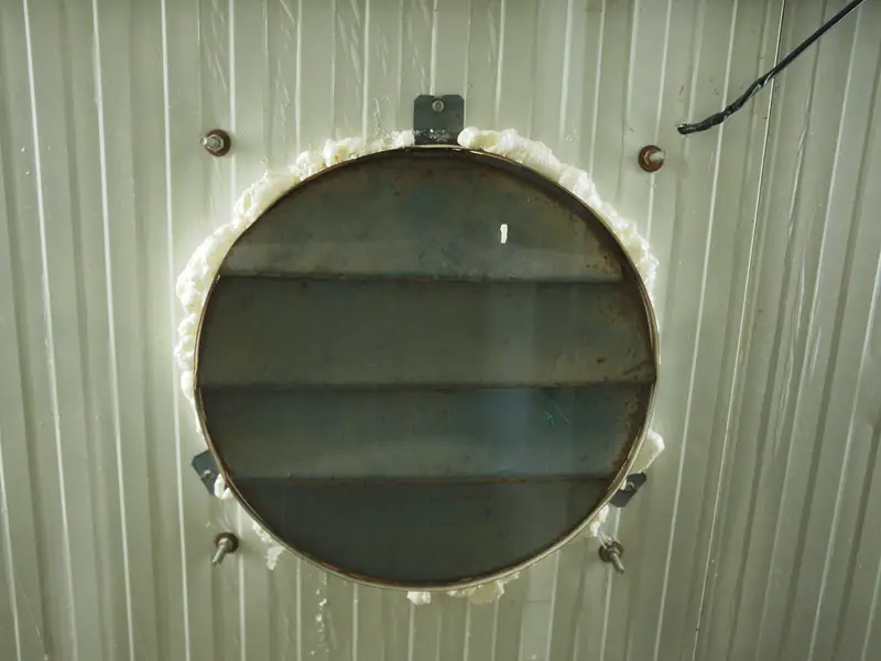 A louvred exhaust shutter set into an insulated panel wall